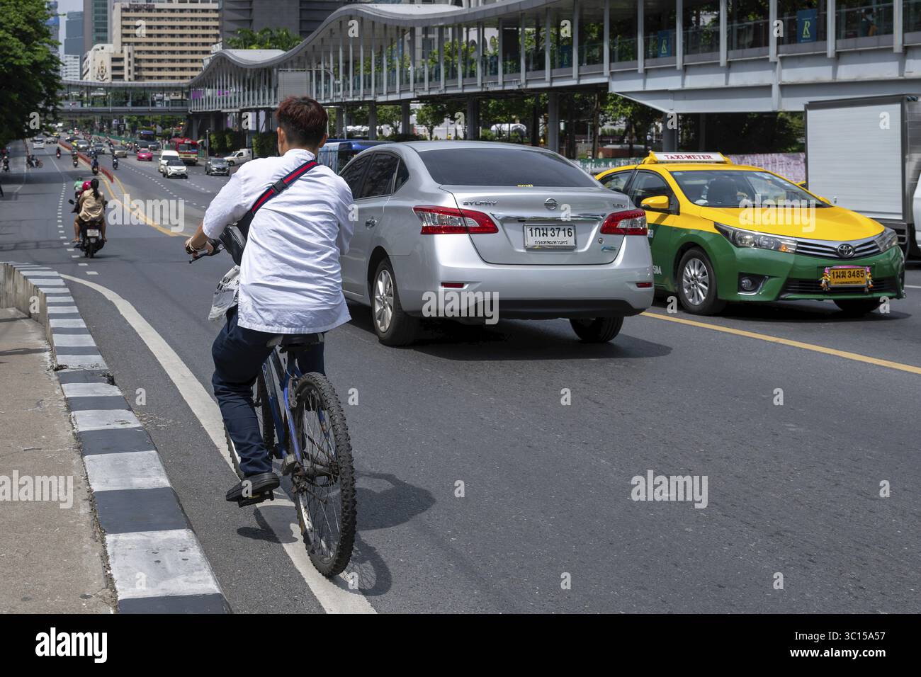 Ciclisti e automobili del traffico stradale, Bangkok, Thailandia Foto Stock