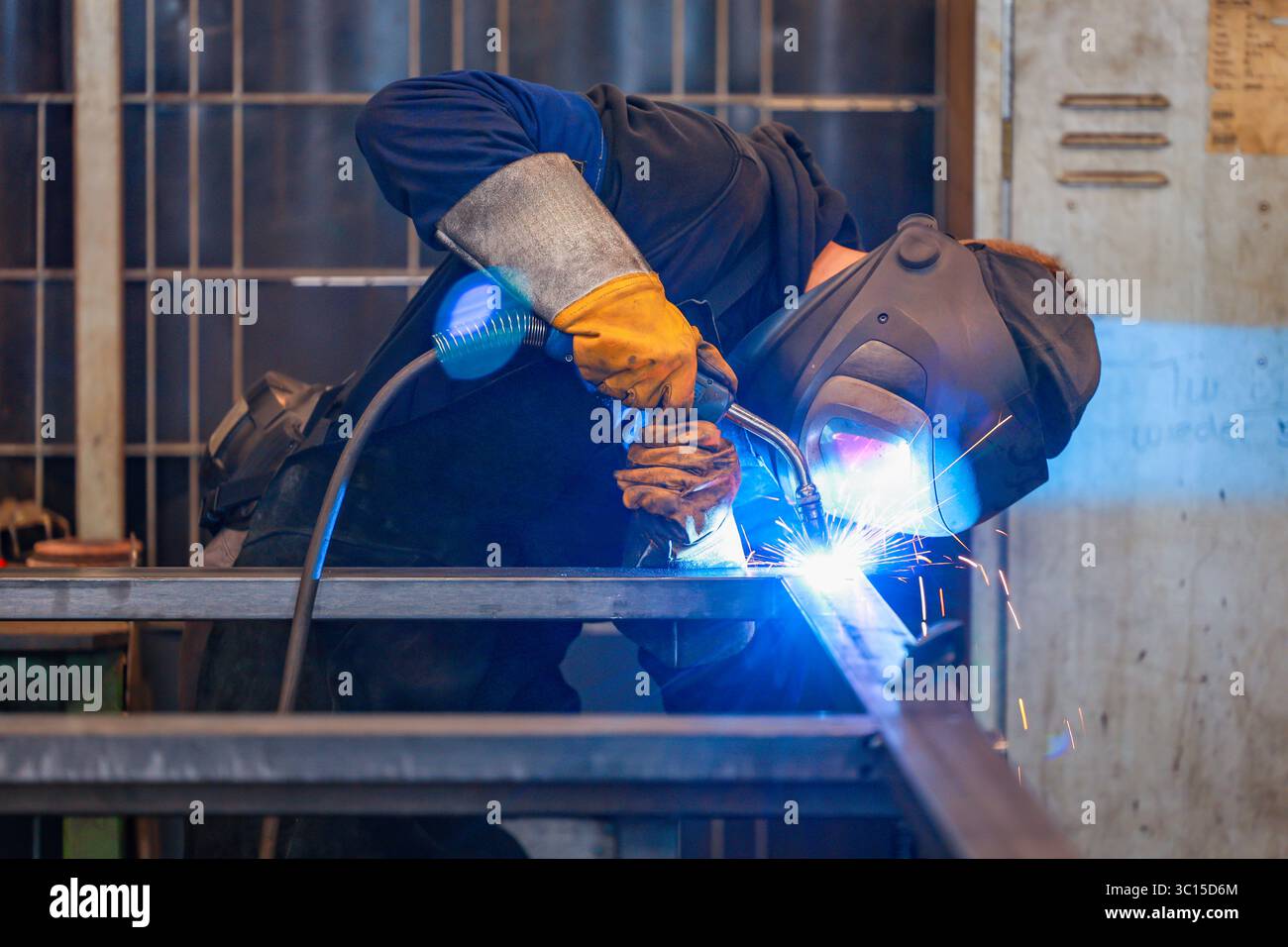 Germania - foto a tema: Industria metallurgica. Una saldatrice industriale salda un pezzo. Foto Stock