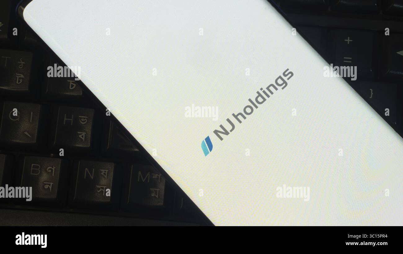 Logo NJ Holdings su un primo piano di un dispositivo sovrapposto a una tastiera Foto Stock