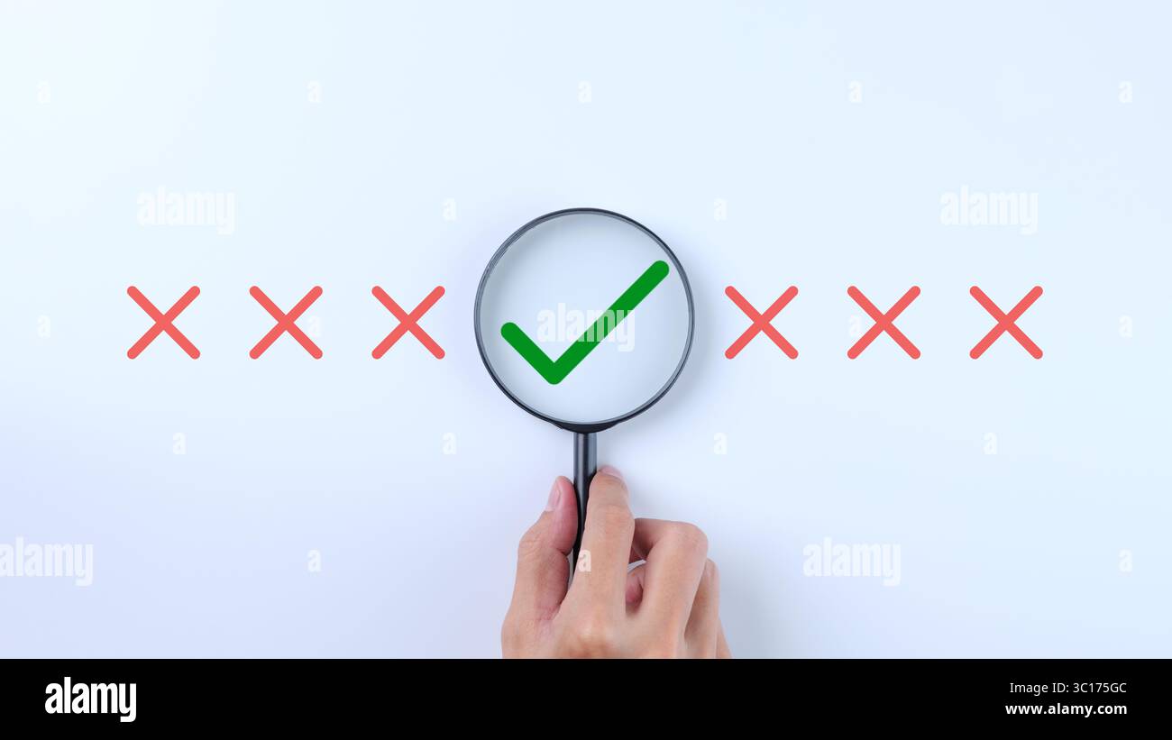 Mano con una lente di ingrandimento per ingrandire il segno di spunta. Correggere il segno di spunta all'interno della lente di ingrandimento, selezionare per approvare e il segno di spunta sbagliato per rifiutare Foto Stock