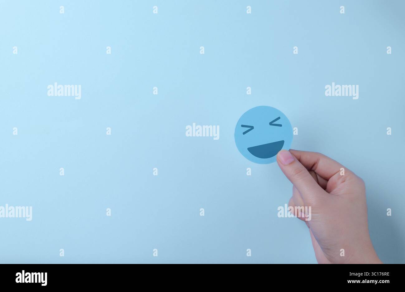 Concetto di salute mentale. Mano che tiene la faccia felice del sorriso. Felicità emozione, pensiero positivo, valutazione della salute mentale, soddisfazione della recensione del cliente Foto Stock