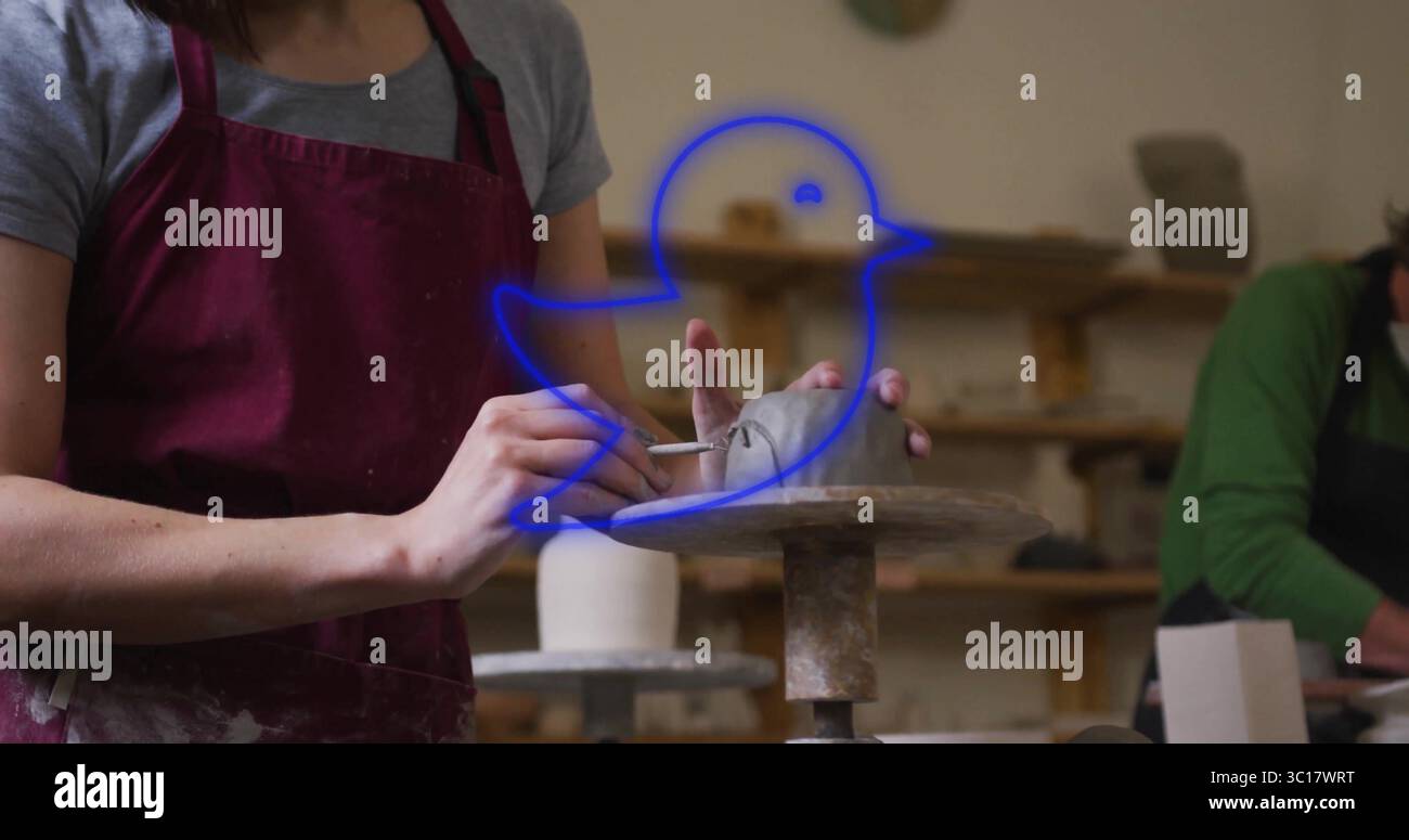 Uomo che indossa un grembiule rosso sulla ruota di ceramica in uno studio di ceramica, utensile a nastro, spazio di copia Foto Stock