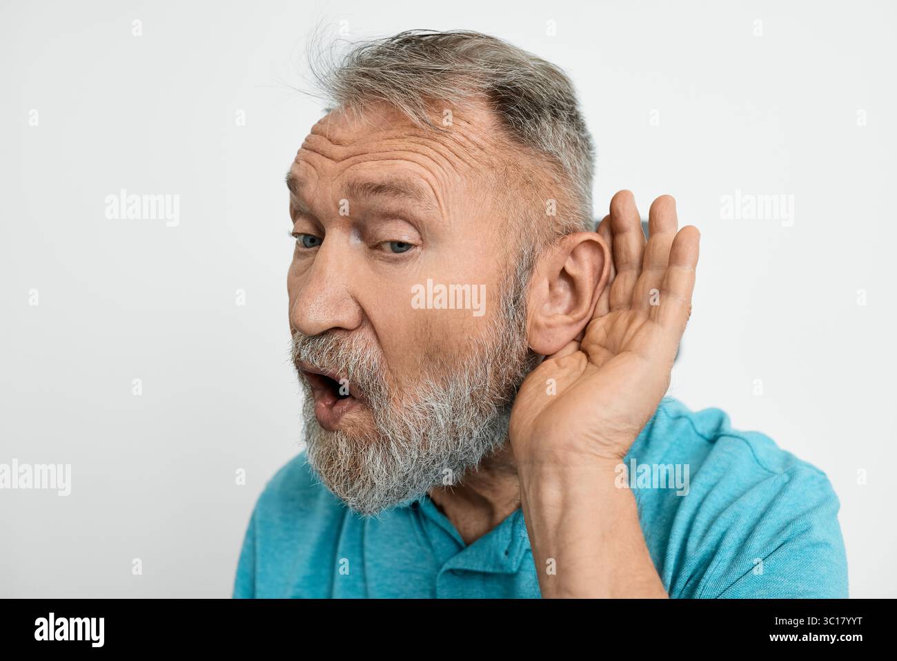 Primo piano di un uomo anziano tenuto per mano vicino all'orecchio, isolato su sfondo bianco. Soluzioni per l'udito Foto Stock