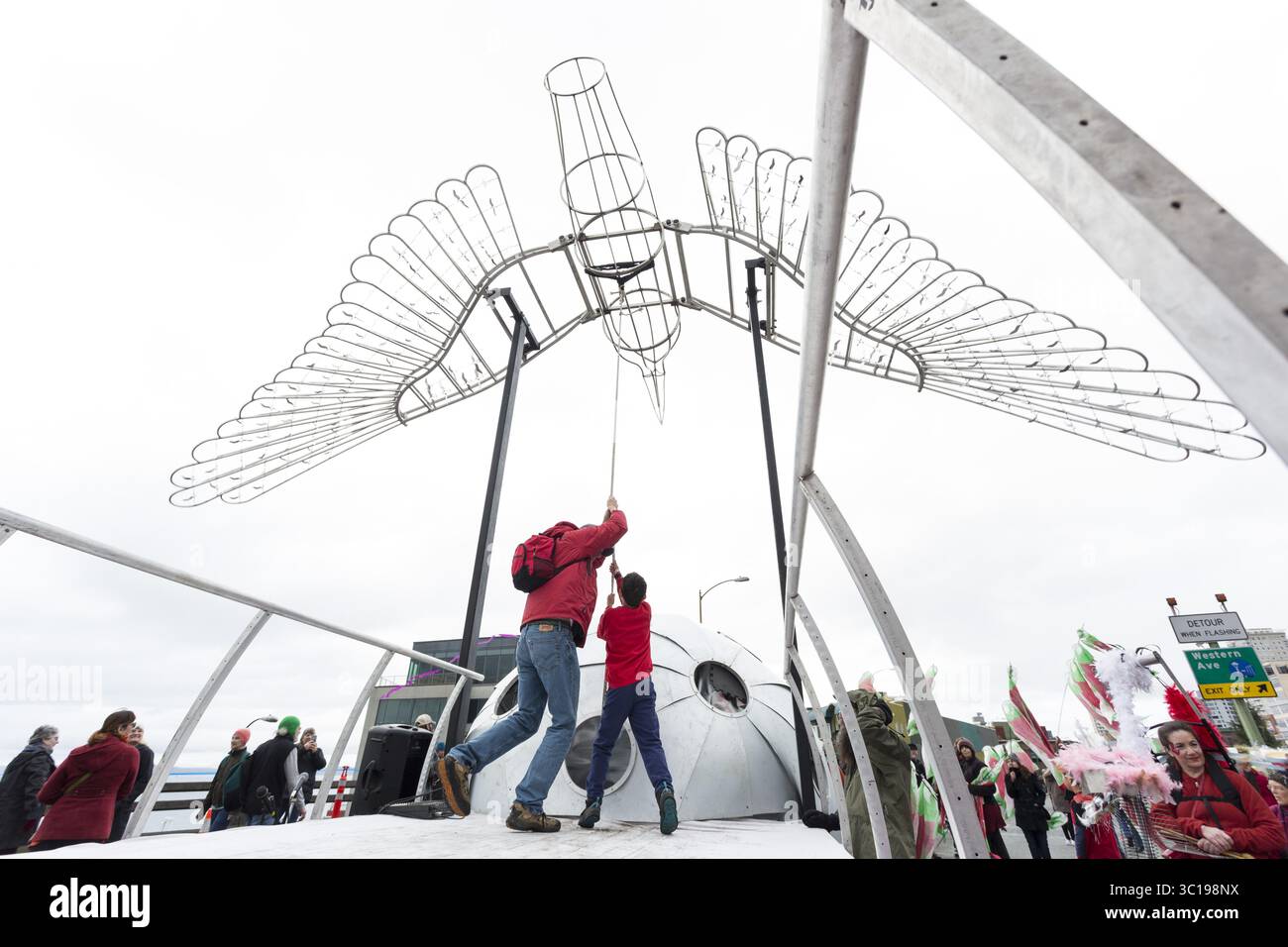 2 febbraio 2019 - Seattle, Washington, Stati Uniti - Seattle, Washington: Un padre e un figlio tirano la corda per sbattere le ali della scultura di uccelli su larga scala di Lela Visionâ lungo il viadotto chiuso della Alaskan Way. Circa 70.000 persone hanno partecipato al Hello Goodbye: Viaduct Arts Festival come parte della grande apertura del tunnel all'avanguardia che si estende per tre chilometri sotto il centro città. Il festival, che si svolse sull'autostrada sopraelevata, iniziò con un processionale che presentava musica e spettacoli di artisti e organizzazioni regionali. Il nuovo tunnel SR 99 è previsto per il 4 febbraio. (Immagine credito: Foto Stock