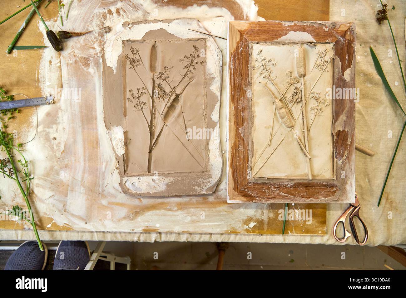 Rilievo in gesso botanico finito e stampo in argilla affiancati. Opere d'arte floreale fai da te in una cornice in legno che mostra dettagli di fiori e foglie, resu Foto Stock