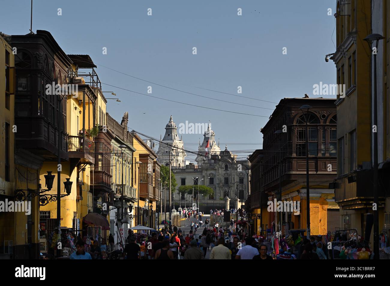 Via Jiron Trujillo nel quartiere Rimac, le torri della Cattedrale di Lima e il Palazzo del governo visibili sullo sfondo. Lima, Perù Foto Stock