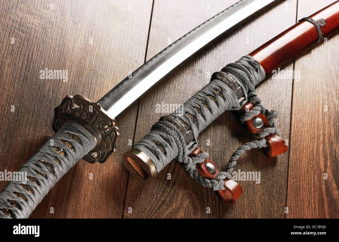 Katana, spada giapponese, su uno sfondo di legno Foto Stock