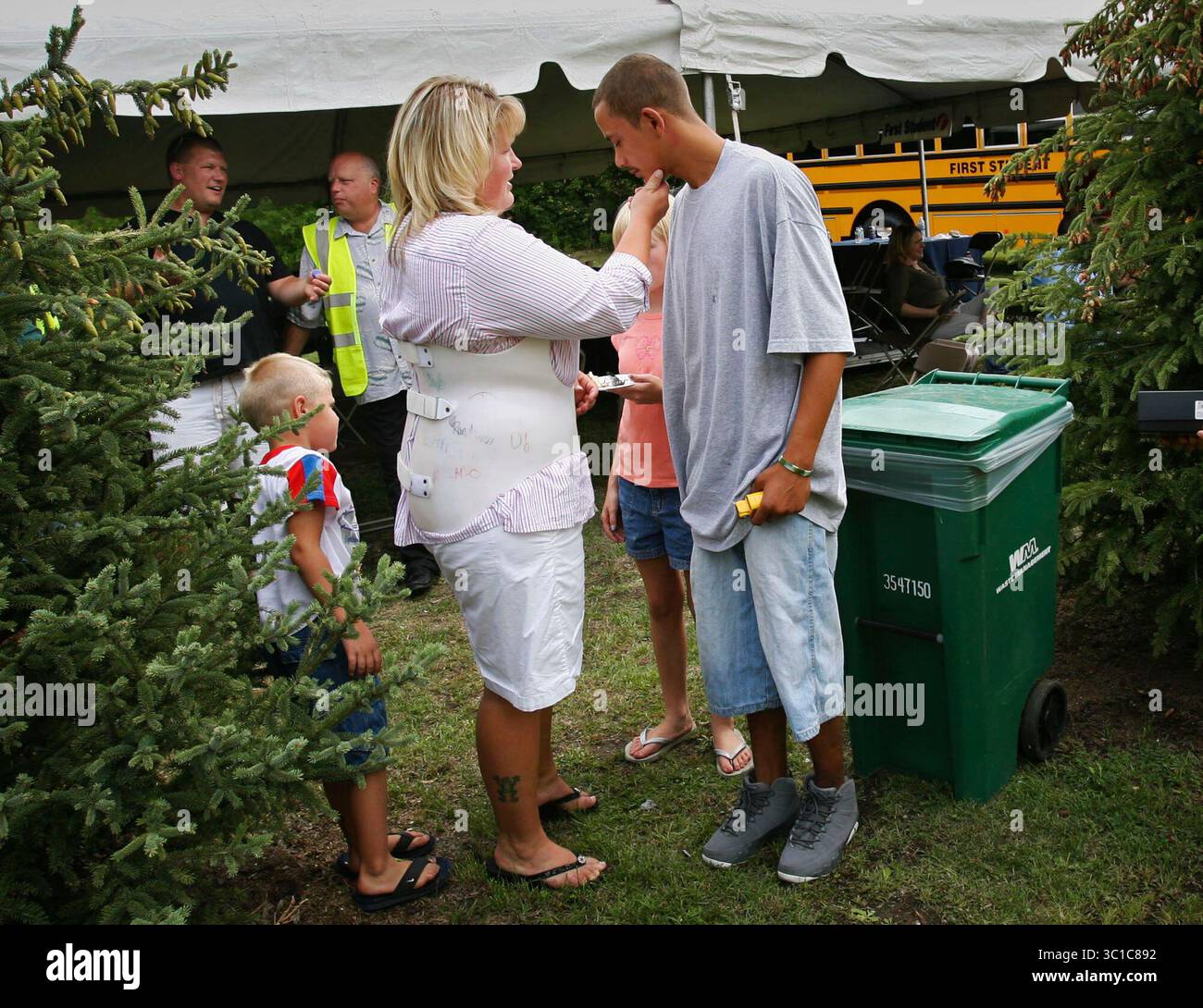 15 agosto 2007 - Arden Hills, Minnesota, Stati Uniti - dopo essersi incontrati nuovamente per la prima volta dopo il crollo del ponte i-35W, l'autista di scuolabus Kim Dahl, centro, dice addio al collega eroe Jeremy Hernandez, che stava viaggiando sull'autobus di Dahl quando è quasi precipitato nel fiume Mississippi. Hernandez aiutò a salvare numerosi bambini dall'autobus e Dahl, che soffriva di fratture da compressione, si aggrappò al volante e tenne il piede sul freno per evitare che l'autobus scivolasse in acqua. La coppia era tra i diversi individui che sono stati onorati dalla First Student Bus Company per la loro salvavita Foto Stock