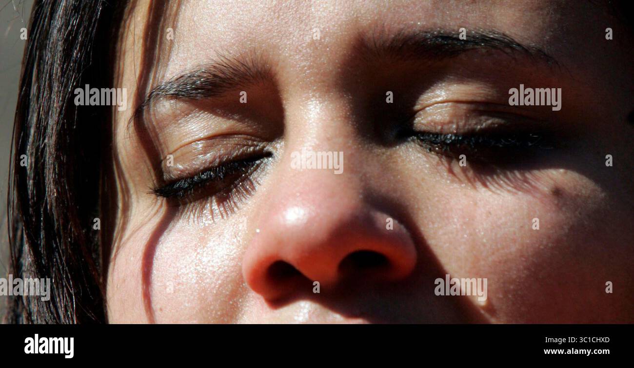01 novembre 2007 - St. Paul, Minnesota, Stati Uniti - Danielle Matthias, studentessa dell'Università di St. Thomas, lascia che le lacrime si rotolino in faccia mentre inchinava il suo hed in un talong di preghiera con una folla di oltre 2000 studenti, docenti e sostenitori durante una marcia e una manifestazione per aiutare a unificare il campus. Tre donne hanno ricevuto appunti razzisti e minacciosi nel loro dormitorio, la John Paul II Hall. (Immagine di credito: Kyndell Harkness/Minneapolis Star Tribune/TNS via cavo ZUMA) Foto Stock