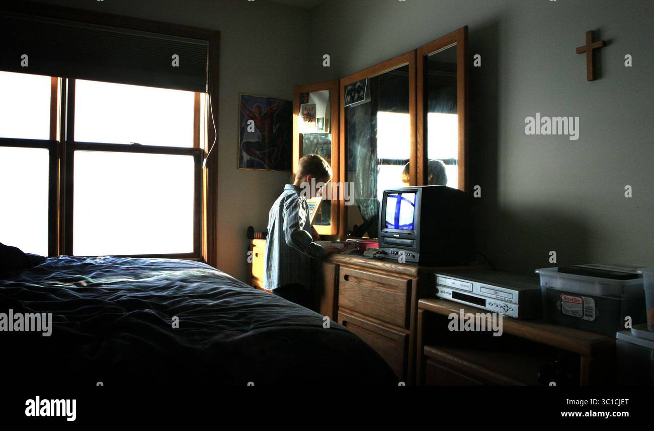 27 febbraio 2008 - Rochester, Minnesota, Stati Uniti - REECE TRAHAN va a scuola con il suo cane autistico Pudge. Reece è legato a Pudge che lo tiene fuori dai guai e fornisce un'influenza confortante. NELLA FOTO: REECE TRAHAN, un bambino autistico, mangia cereali secchi nella sua stanza mentre aspetta di prendere lo scuolabus. Dopo quasi un anno insieme, Reece e il suo cane, Pudge, affronteranno un'altra sfida: Il loro primo giorno di scuola, insieme. (Immagine di credito: Steve Rice/Minneapolis Star Tribune/TNS via cavo ZUMA) Foto Stock