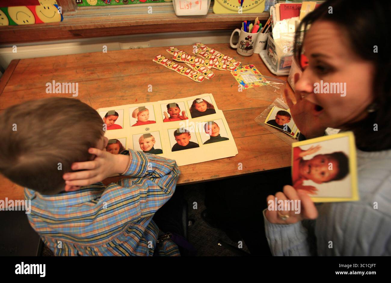 27 febbraio 2008 - Rochester, Minnesota, Stati Uniti - REECE TRAHAN va a scuola con il suo cane autistico Pudge. Reece è legato a Pudge che lo tiene fuori dai guai e fornisce un'influenza confortante. NELLA FOTO: REECE TRAHAN, a sinistra, un bambino autistico e il suo insegnante di educazione speciale KORI lavorano sul riconoscimento facciale mentre gli mostra una foto che illustra la sorpresa. Lei stessa imita quell'espressione. (Immagine di credito: Steve Rice/Minneapolis Star Tribune/TNS via cavo ZUMA) Foto Stock