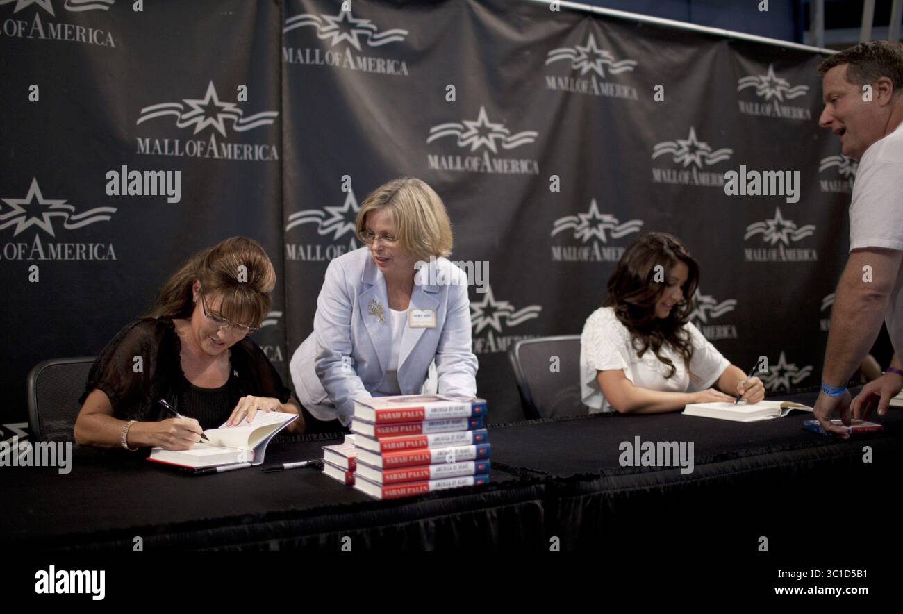 29 giugno 2011 - Bloomington, MN, Stati Uniti - l'ex governatore dell'Alaska Sarah Palin, a sinistra, si sedette e ottenne il diritto di firmare libri mentre la prima persona in fila, Myron Hovda di Woodbury, fece firmare il suo libro da sua figlia, Bristol, a destra, durante il loro evento congiunto al Mall of America di Bloomington, Minn., mercoledì pomeriggio, 29 giugno 2011. Tra di loro c'è un dipendente non identificato di Barnes & Noble che gestiva i libri a Palin. Myron Hovda (immagine di credito: Jeff Wheeler/Minneapolis Star Tribune/TNS via cavo ZUMA) Foto Stock
