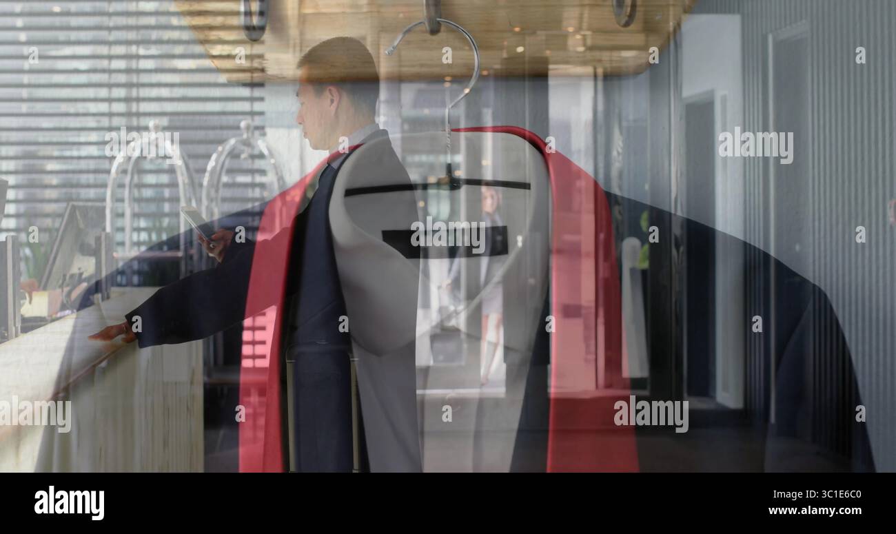 Mostra la giacca rivestita con un blazer rosso su un appendiabiti alla reception dell'hotel, con l'uomo che punta Foto Stock