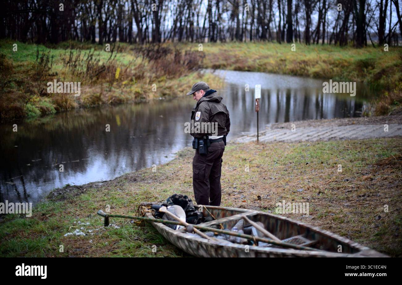 28 ottobre 2015 - Shakopee, Minnesota, Stati Uniti - l'ufficiale federale della fauna selvatica Scott Pariseau ha fatto un controllo di conformità con un cacciatore appena uscito dall'acqua. Mercoledì 28 ottobre 2015 giorno nella vita dell'ufficiale federale della fauna selvatica Scott Pariseau mentre controllava i cacciatori di anatre presso la Wilkie Trail Unit sotto la rampa di accesso sotto l'autostrada. 169 a Shakopee. (Immagine di credito: Glen Stubbe/Minneapolis Star Tribune/TNS via cavo ZUMA) Foto Stock