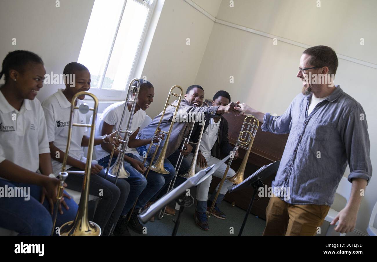 12 agosto 2018 - Durban, Minnesota, SUD AFRICA - il trombone della Minnesota Orchestra Andrew Chappell saluta i membri della KwaZulu Natal Youth Wind Band dopo una sessione di breakout. ...INFORMAZIONI DI BASE: Un gruppo dell'Orchestra del Minnesota visita la KwaZulu Natal Youth Wind Band per un'attività di fidanzamento alla Durban Music School di Durban, in Sudafrica, domenica 12 agosto 2018. (Immagine di credito: Leila Navidi/Minneapolis Star Tribune/TNS via cavo ZUMA) Foto Stock