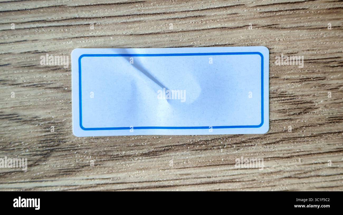 Etichetta bianca vuota con bordo blu su sfondo in legno Foto Stock