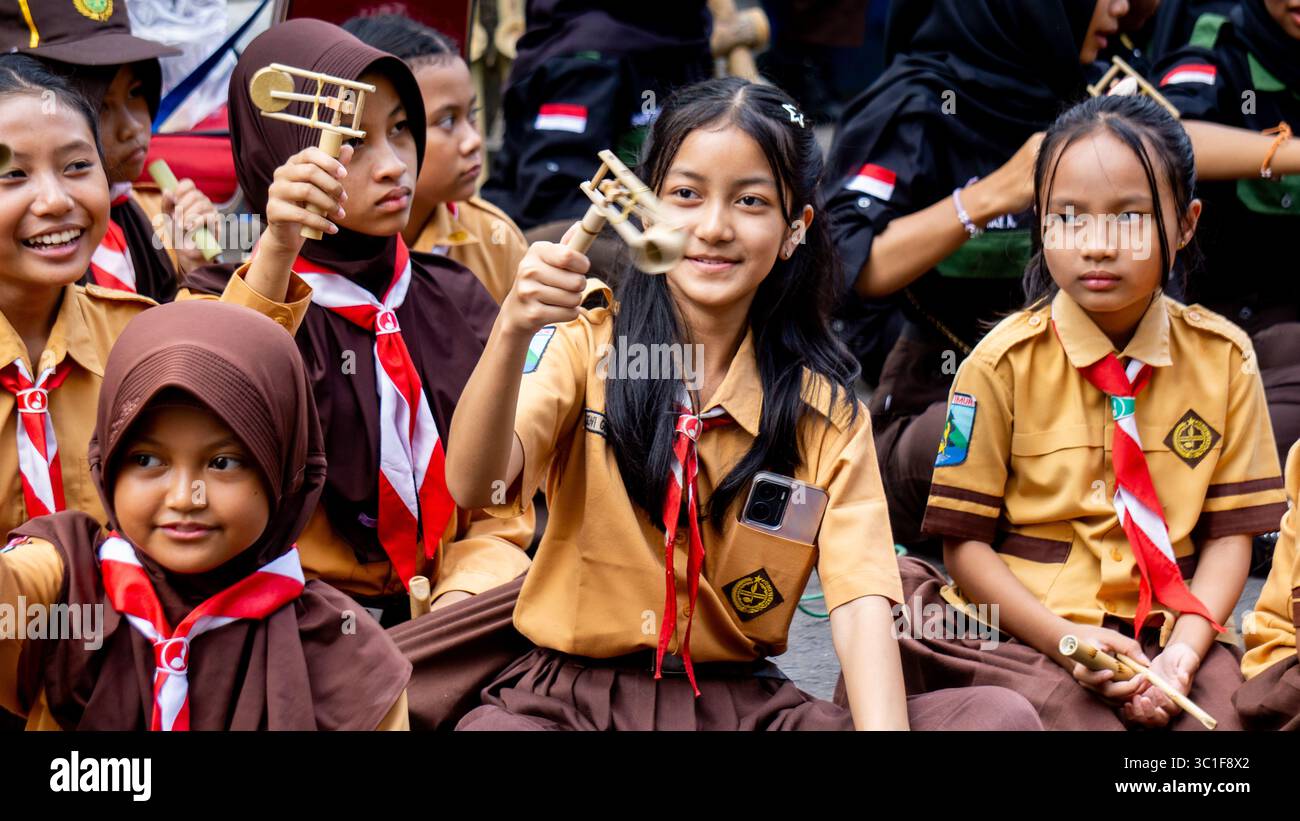 Giocare a giocattoli tradizionali (klotokan, otok-otok) in bambù. Il modo di giocare è girarlo Foto Stock