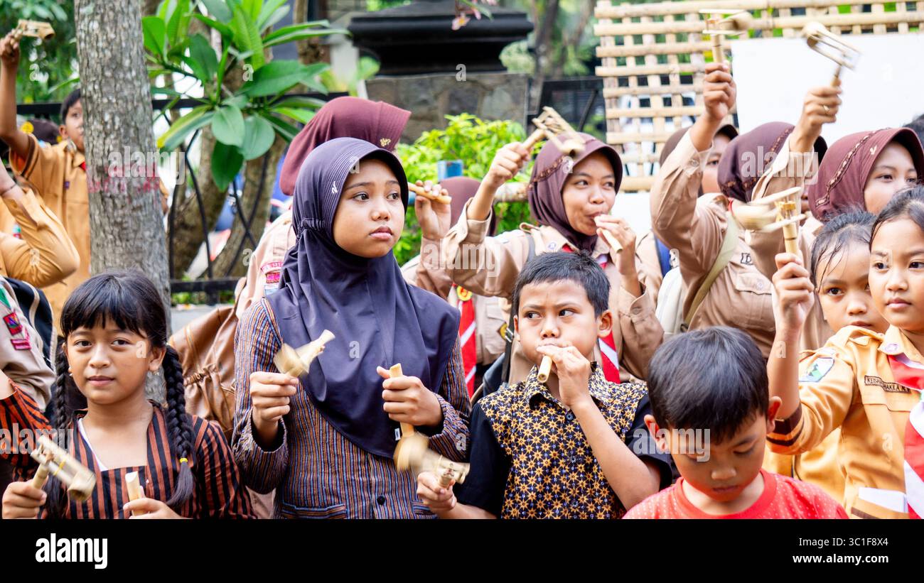 Giocare a giocattoli tradizionali (klotokan, otok-otok) in bambù. Il modo di giocare è girarlo Foto Stock