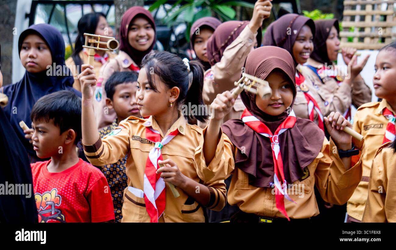 Giocare a giocattoli tradizionali (klotokan, otok-otok) in bambù. Il modo di giocare è girarlo Foto Stock