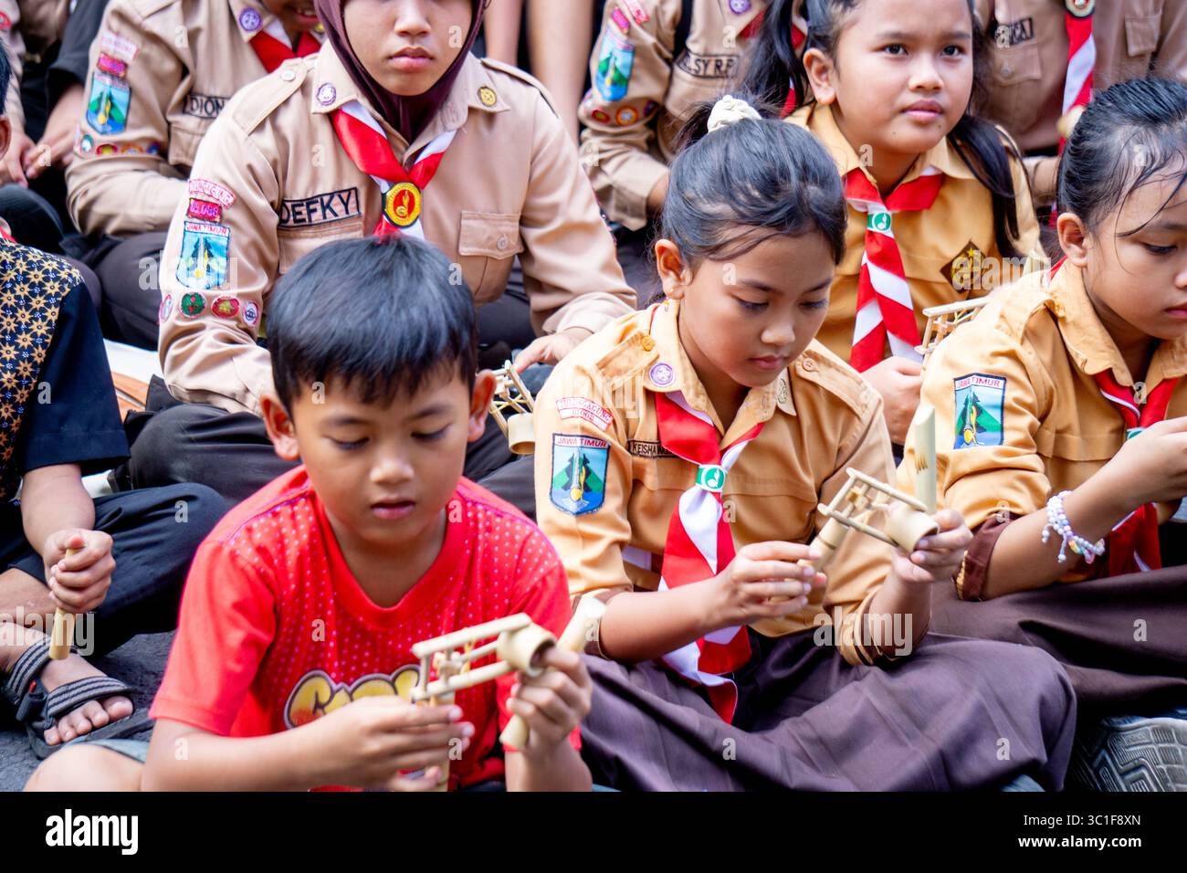 Giocare a giocattoli tradizionali (klotokan, otok-otok) in bambù. Il modo di giocare è girarlo Foto Stock