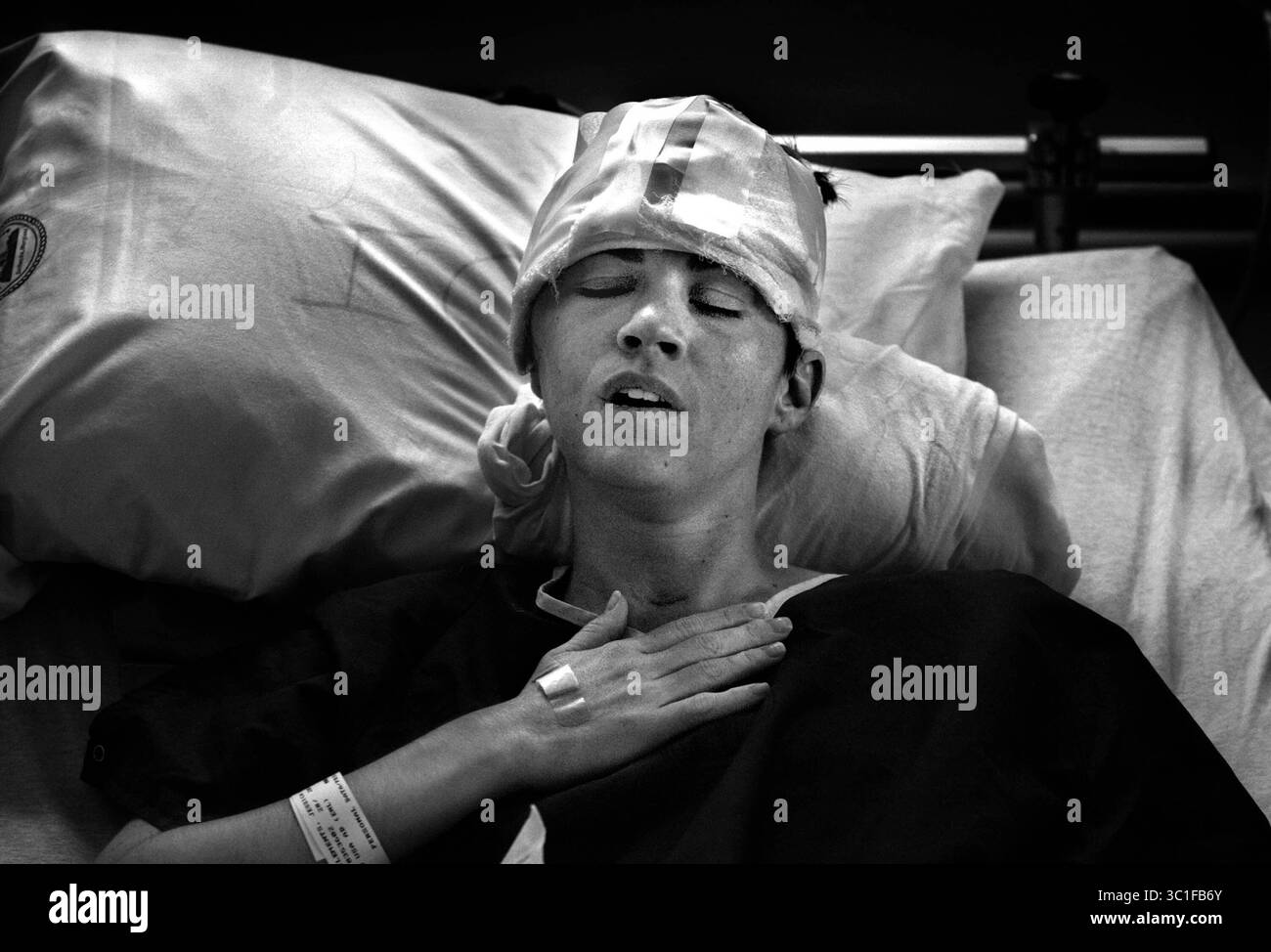 19 agosto 2004; Bethesda, MD, USA; JESSICA CLEMENTS, 27 anni, si riprende in un letto d'ospedale del National Naval Medical Center di Bethesda, Maryland, dopo essere stata sottoposta a un intervento chirurgico per riparare una parte del suo cranio che era stata rimossa per alleviare il gonfiore nel cervello. Clements è in grado di regolare alcuni dei suoi farmaci antidolorifici da sola premendo un pulsante attaccato al farmaco. (Immagine di credito: Jim Gehrz/Minneapolis Star Tribune/TNS via cavo ZUMA) Foto Stock