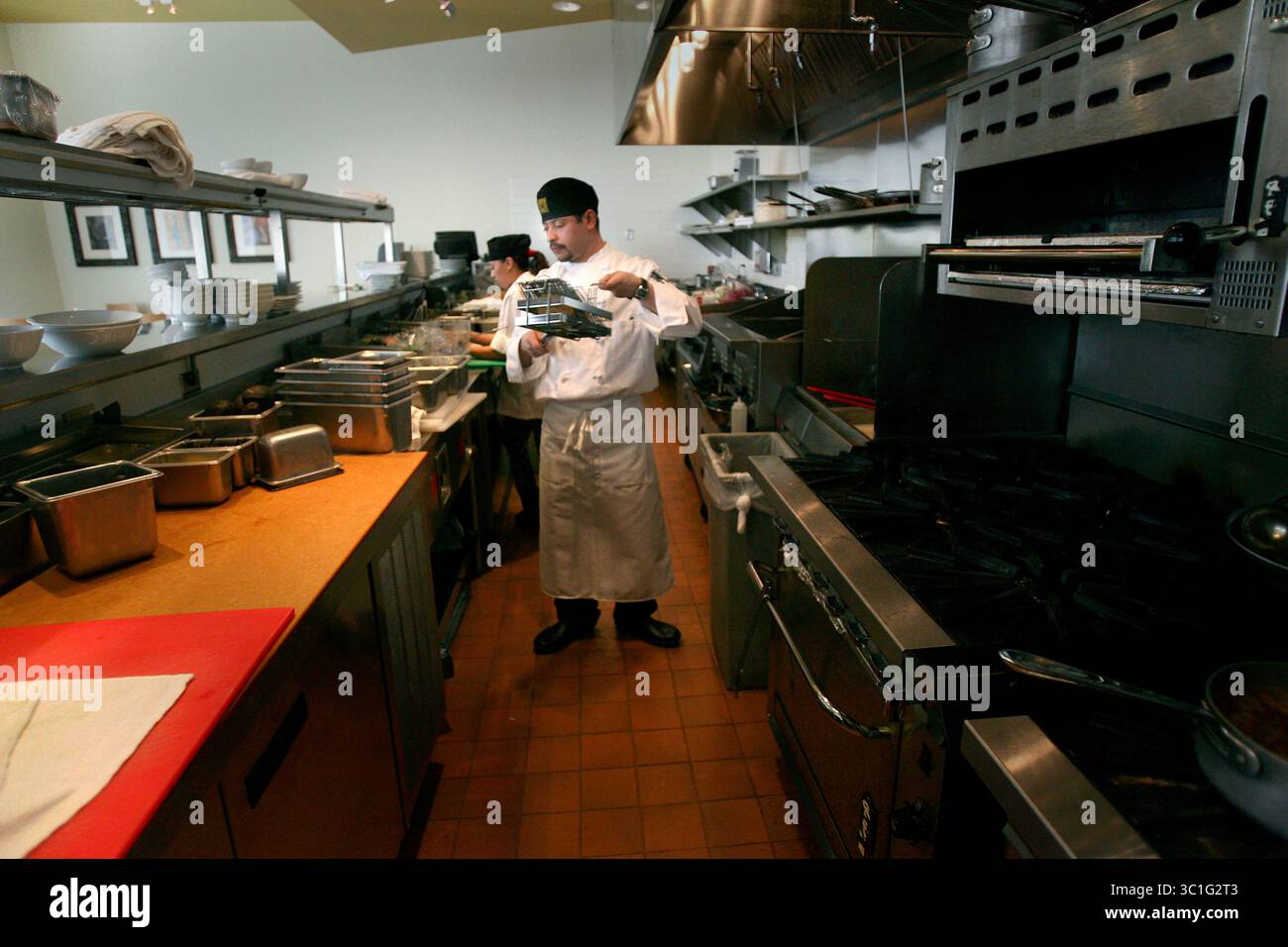 4 marzo 2006; Minneapolis, Minnesota, Stati Uniti; "ne è valsa la pena", afferma Jacobo Montero mentre prepara il cibo al ristorante Masa nel centro di Minneapolis. Montero è venuto negli Stati Uniti circa dodici anni fa per stare con sua madre, Esperanza Montero. Ha vissuto qui illegalmente mentre aspettava l'approvazione dei documenti per l'immigrazione. Ci sono voluti 11 anni dal momento in cui li ha depositati in Messico nel 1994, fino al momento in cui ha ottenuto la residenza permanente l'anno scorso. Ha iniziato come lavastoviglie in California e Minnesota e ora si è fatto strada per diventare uno chef. Credito obbligatorio: Foto di /Minneapolis Star/ZUMA Press Foto Stock