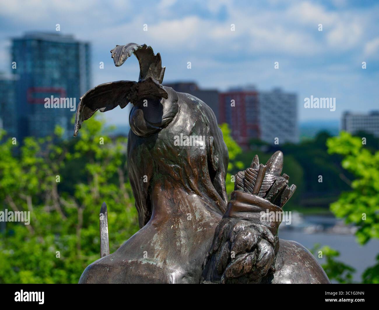 Vista ravvicinata della testa da dietro la statua di Kichi Zhou, guardando l'edificio "VIU" a Gatineau. Statua situata al Kiweki Point di Ottawa, Onta Foto Stock