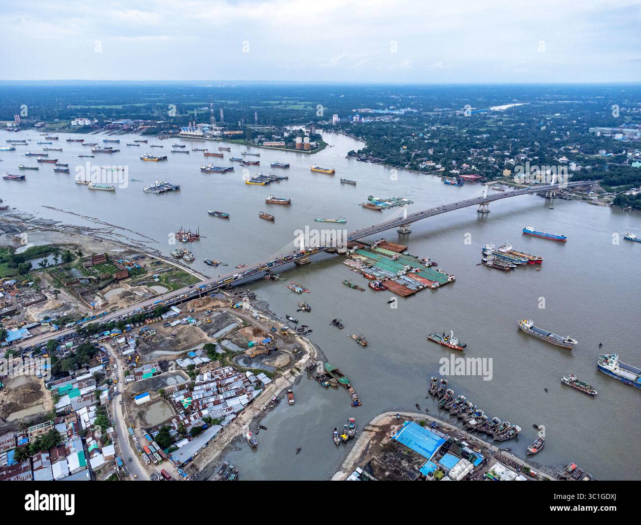 Ponte con vista aerea, barca, edifici e centinaia di navi ancorate nel fiume Karnafuli vicino al porto di Chattogram, sulla costa della baia del Bengala Foto Stock