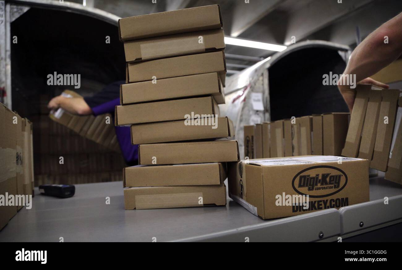 14 maggio 2012 - Thief River Falls, Minnesota, Stati Uniti - il dipendente della FedEx James Mathrews, a sinistra, carica un branco di spedizione con pacchetti da Digi-Key per clienti provenienti da 170 paesi in tutto il mondo presso il magazzino Digi-Key martedì 14 maggio 2013 a Thief River Falls, Minnesota. Sono così tanti i pacchi spediti da Digi-Key che FedEx, UPS e DHL hanno impostato operazioni di spedizione all'interno di Digi-Key. La contea di Pennington è un'isola di crescita in un mare di contrazione economica nel nord-ovest del Minnesota. Dal 2000, la crescita dell'occupazione nella contea ha quadruplicato la crescita della popolazione, rendendola un'anomalia sia a livello statale che nel no Foto Stock