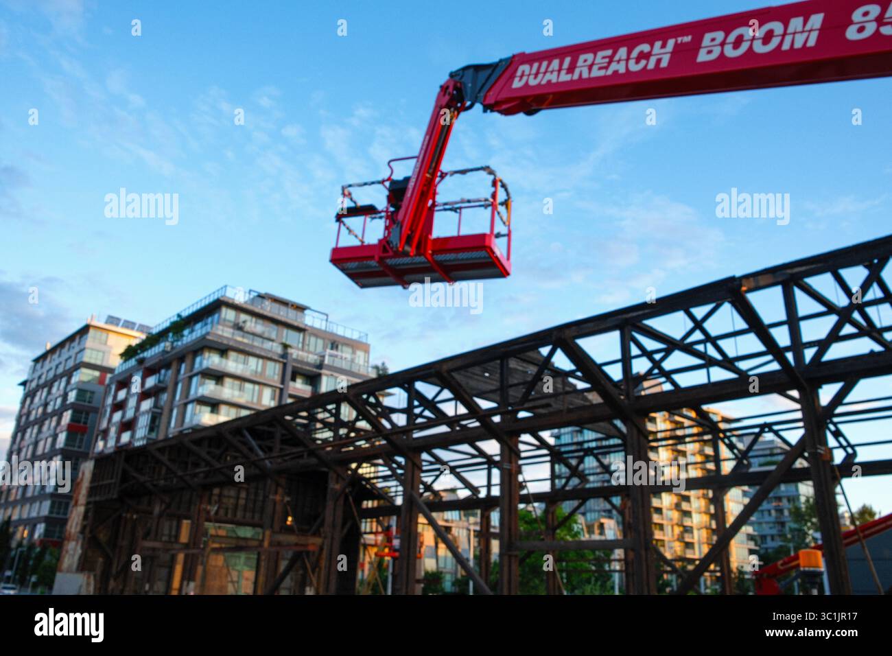 Una gru si appoggia durante lo smantellamento del 1st Ave Plant Building nel villaggio olimpico di Vancouver, BC. Foto Stock