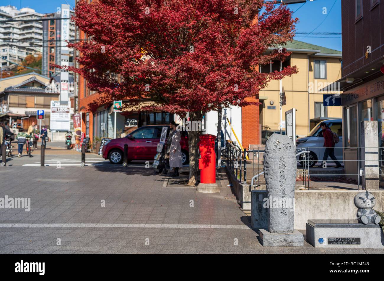 Minoh, Osaka, Giappone - 7 dicembre 2024: Pietra per il punto di partenza ovest del Tokai Nature Trail circondata dal fogliame autunnale di Minoh. Foto Stock