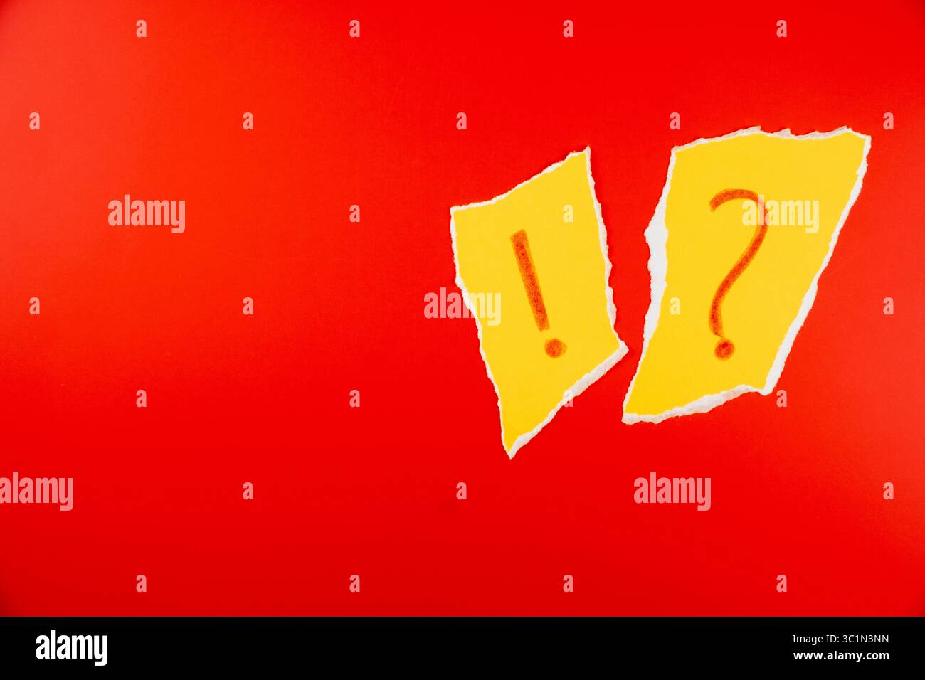 Carta gialla strappata con punto esclamativo e punto interrogativo ?!? su sfondo rosso brillante per immagini accattivanti nel marketing e nella comunicazione Foto Stock