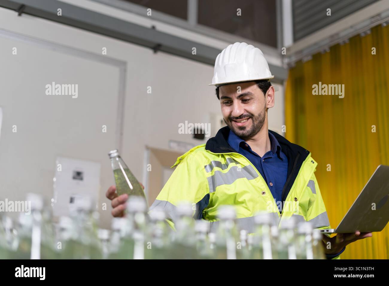 Fabbrica di alimenti o bevande, il tecnico controlla il trasportatore per bottiglie di alimentazione, alimenti o bevande in magazzino prima di inviare il prodotto al cliente. Qualità Foto Stock