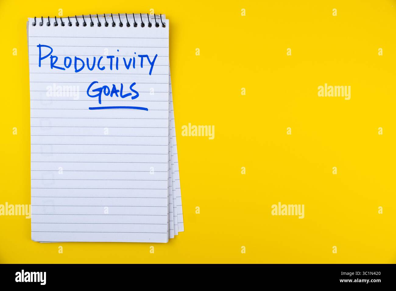Notebook con obiettivi di produttività scritti a mano su sfondo giallo per pianificazione e motivazione, pianificazione della produttività in background Foto Stock