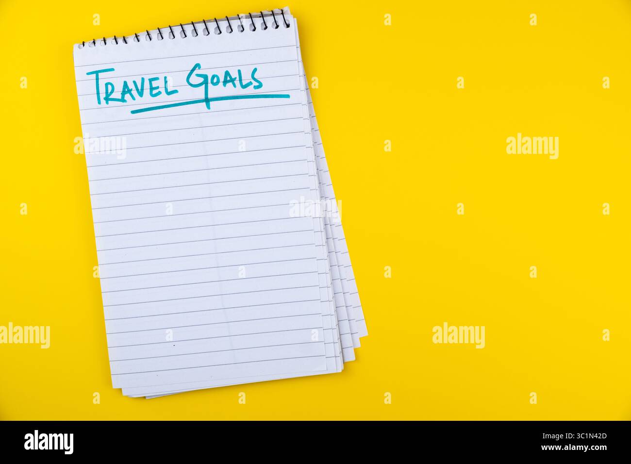 Blocco note degli obiettivi di viaggio con pagine vuote su sfondo giallo brillante per pianificare vacanze e avventure Foto Stock