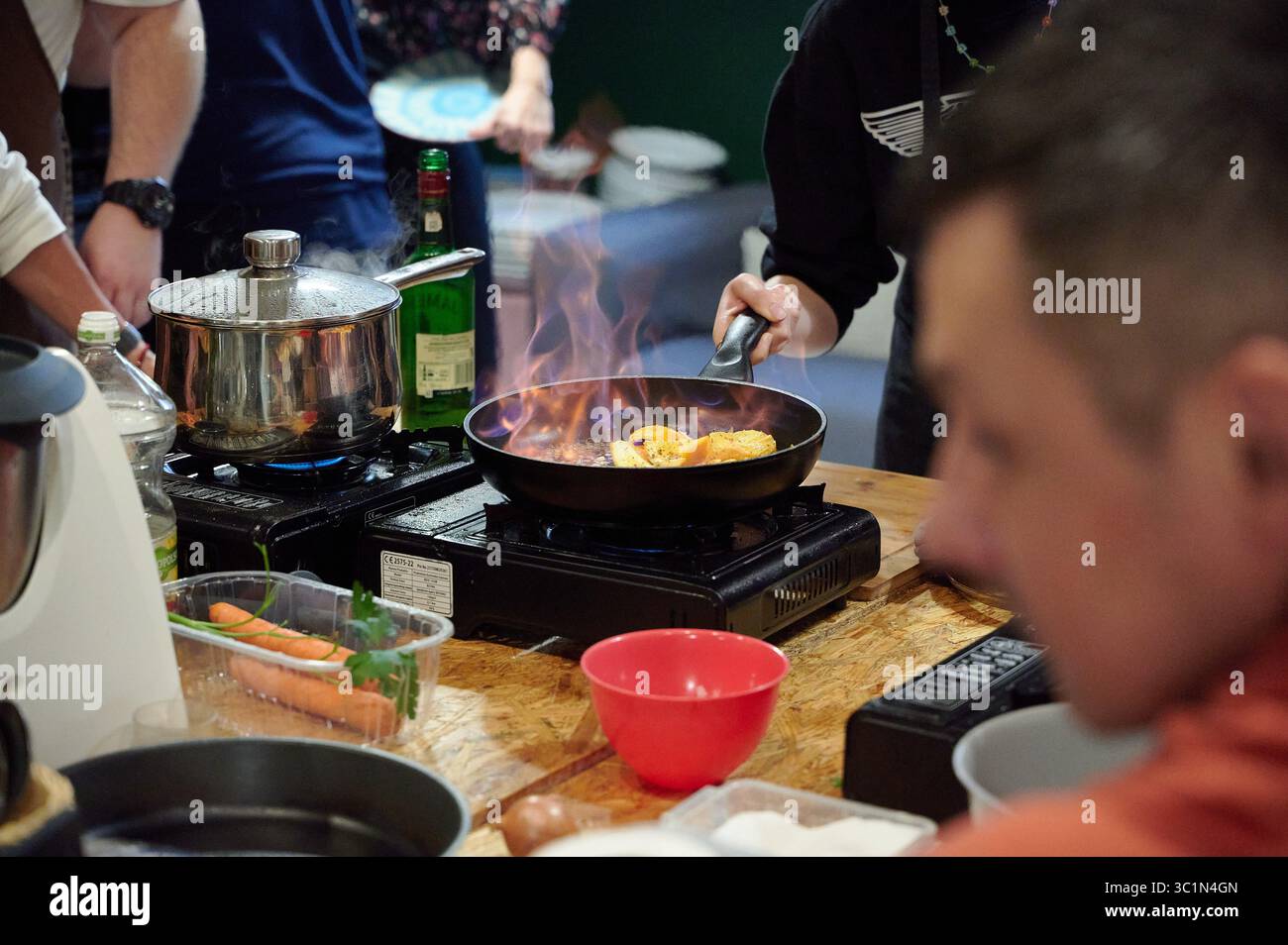 Lo chef prepara il cibo in padella durante la dimostrazione di cucina Foto Stock