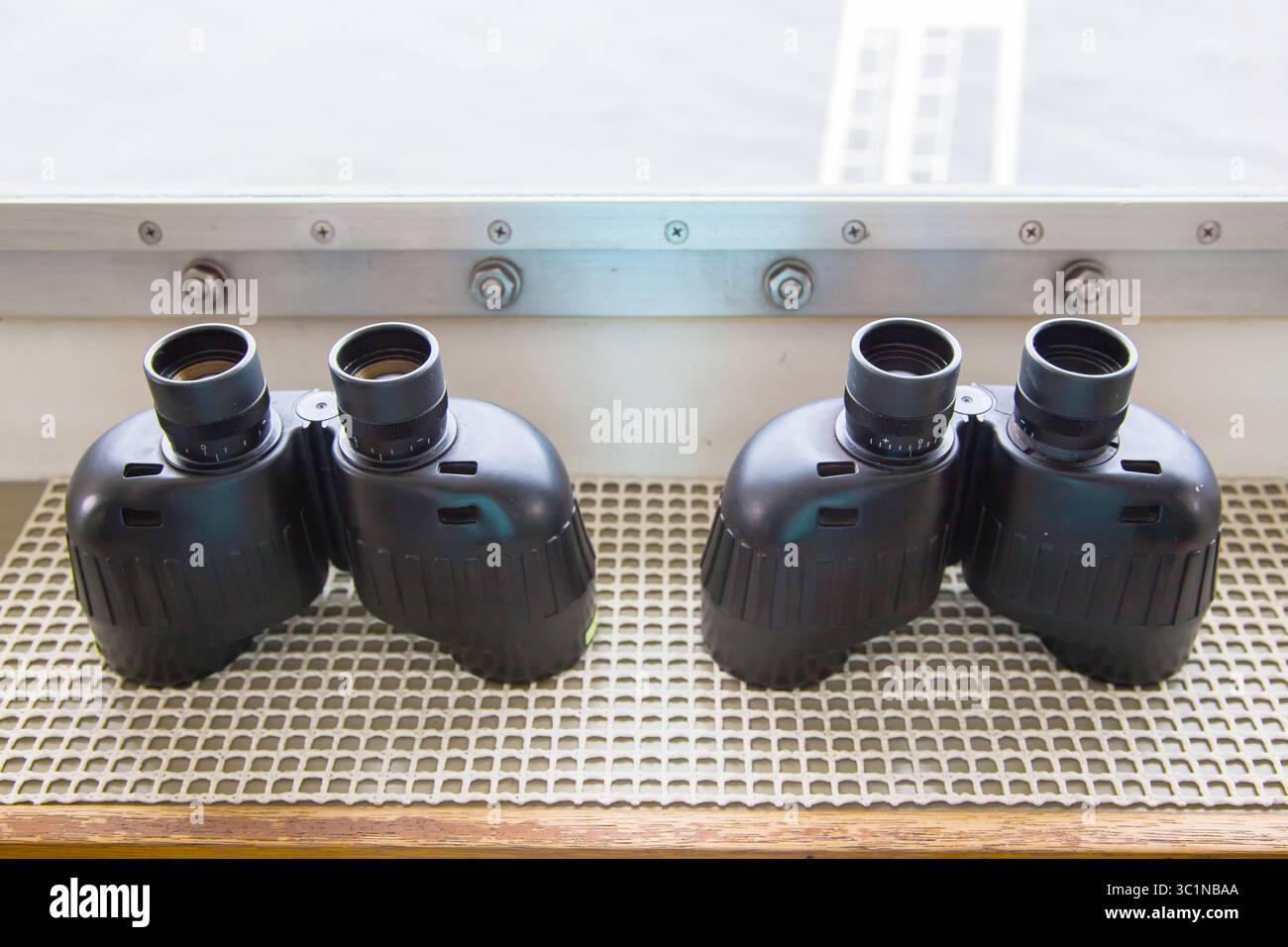 Diversi binocoli su un ponte navale vicino all'oblò. Foto Stock