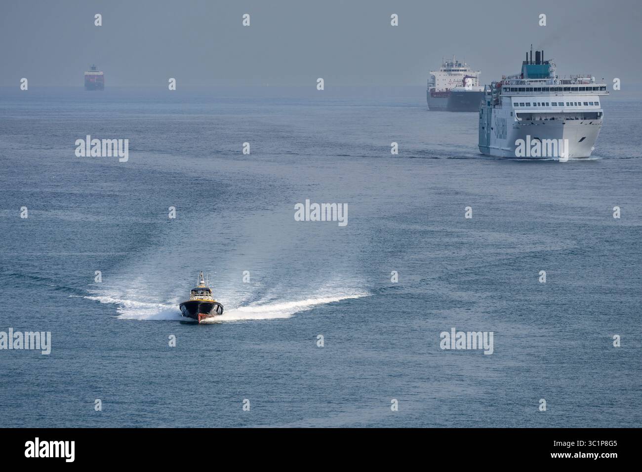 Pilota di porto che naviga di fronte alle navi che accedono al porto di Barcellona, Catalogna, Spagna. Foto Stock