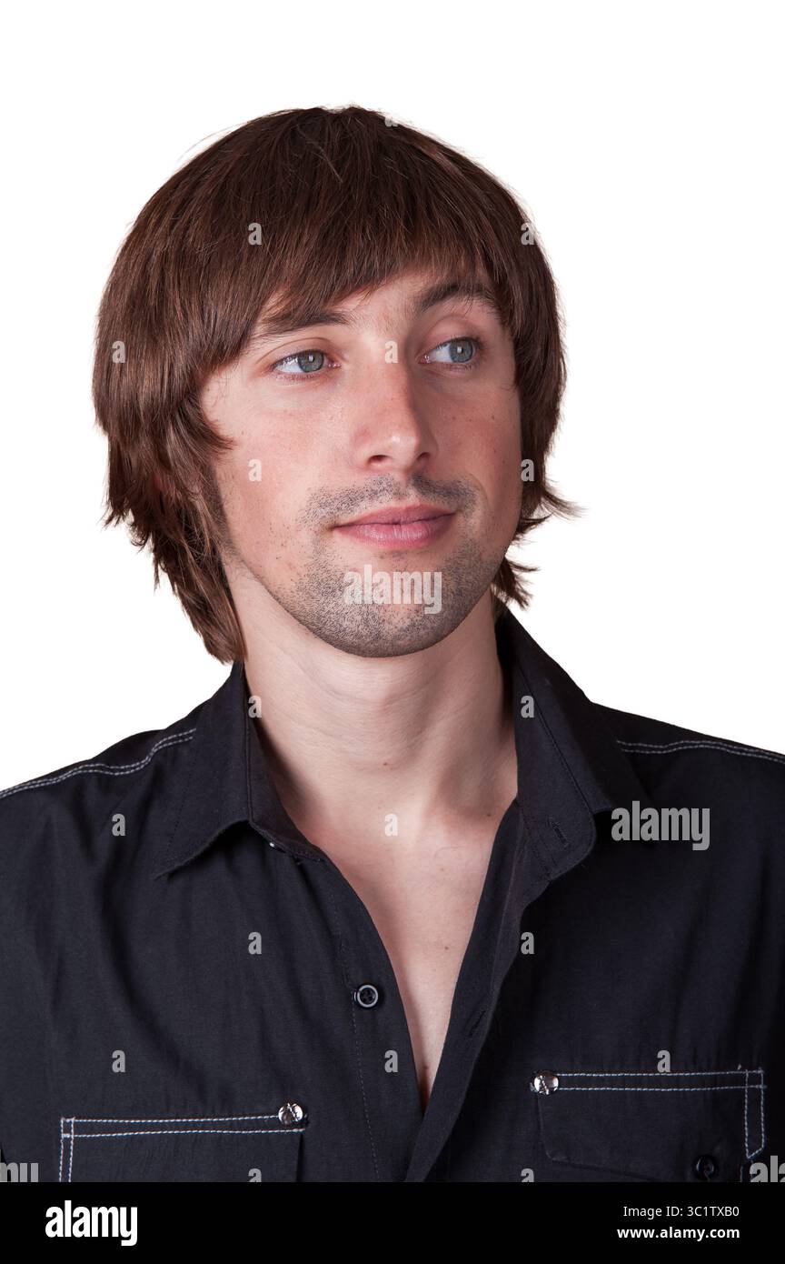 Giovane uomo con capelli voluminosi e camicia casual guarda attentamente, incarnando la fiducia. Foto Stock