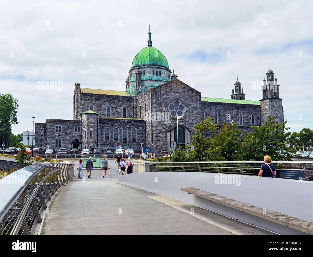 Una vista della cattedrale di Galway dal nuovo ponte pedonale chiamato Droichead an Dochais in irlandese, il Ponte della speranza, sul fiume Corrib Foto Stock