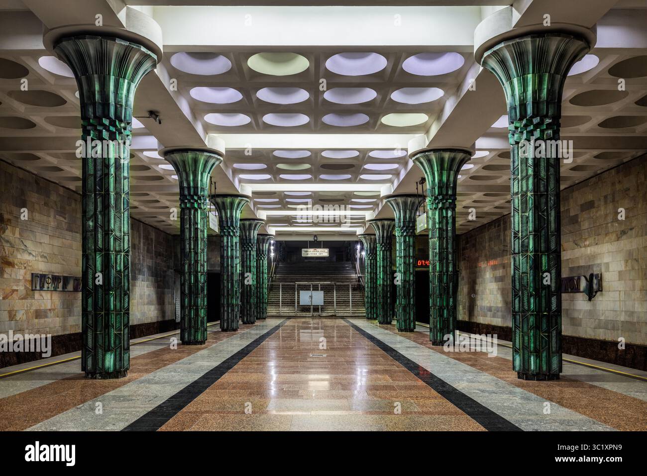 Tashkent, Uzbekistan - 5 aprile 2024: Vista della stazione della metropolitana con le sue maestose colonne scanalate che riflettono la luce attraverso i pavimenti in marmo lucido. Foto Stock
