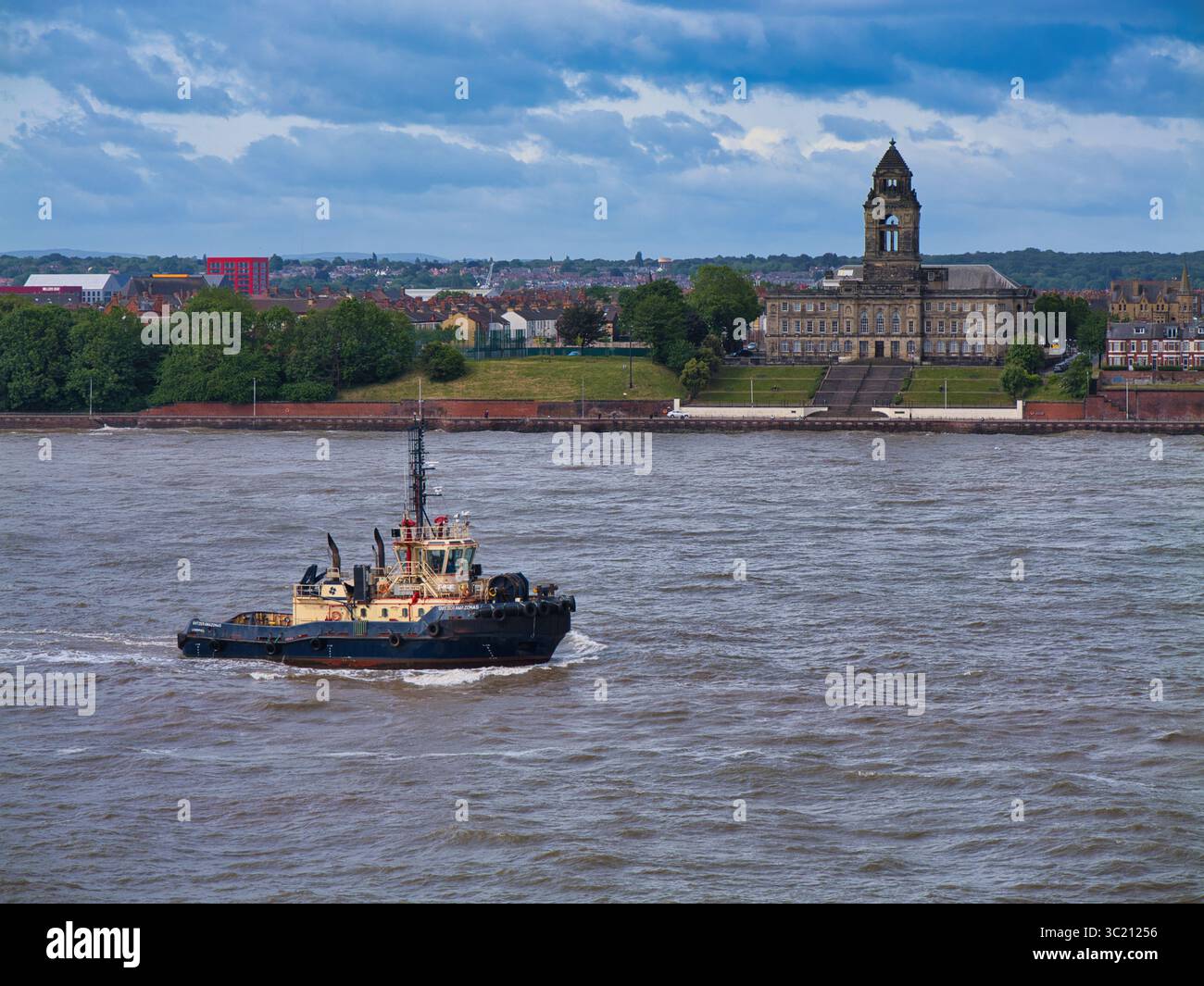 Fiume Mersey, Regno Unito - maggio 26 2025: Il rimorchiatore Svitzer Amazonas naviga sul fiume Mersey, con il Wallasey Town Hall maestosamente sullo sfondo. Foto Stock