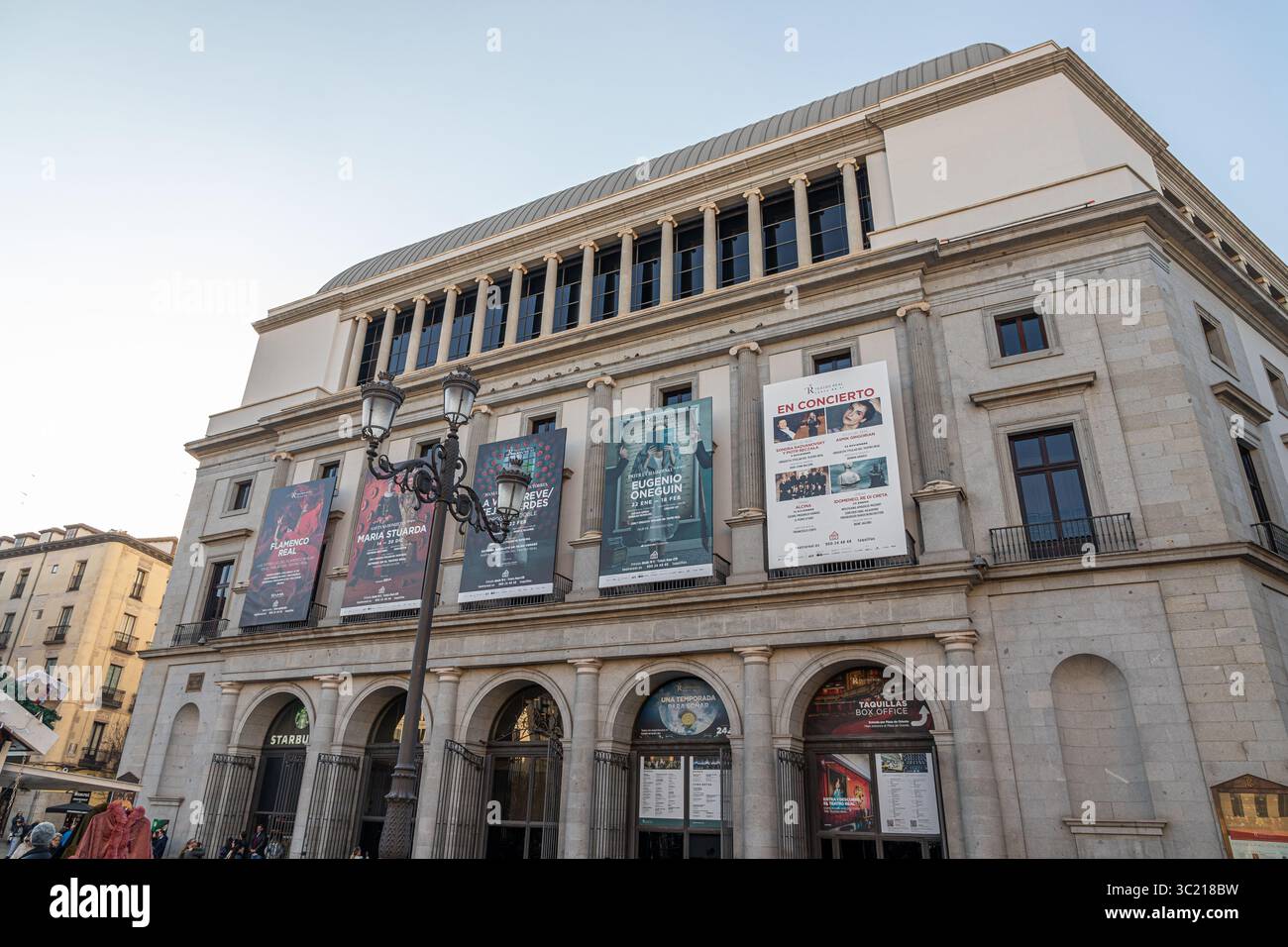 Madrid, Spagna. Facciata orientale del Teatro Real di fronte a Plaza de Isabel II, con manifesti che pubblicizzano le produzioni liriche attuali e future appese fr Foto Stock