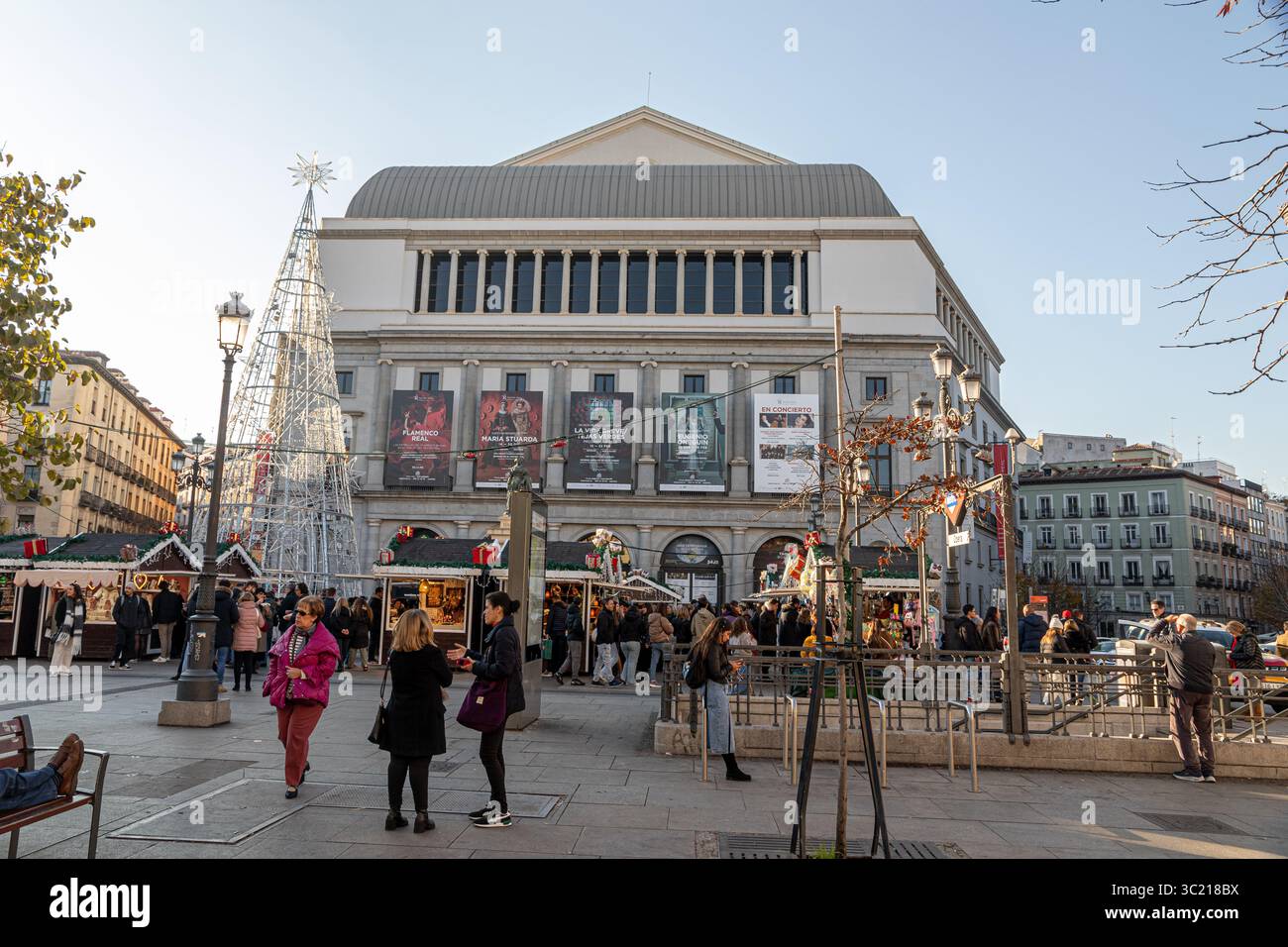 Madrid, Spagna. Facciata orientale del Teatro Real con bancarelle stagionali di Natale allestite in Plaza de Isabel II, che combinano architettura classica Foto Stock