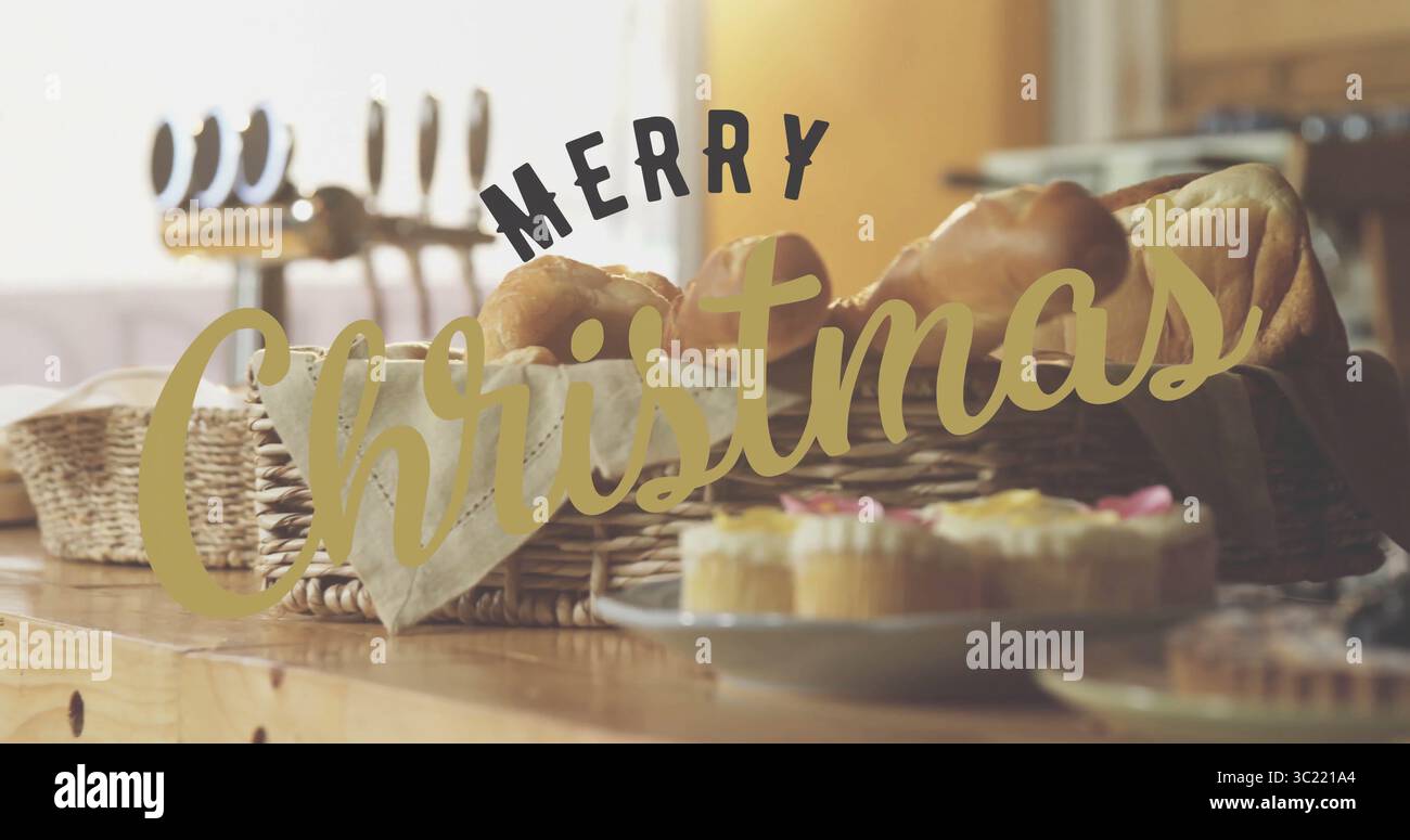 Con cesto di vimini che contiene croissant e panini in cucina, con cupcake e saluto natalizio Foto Stock