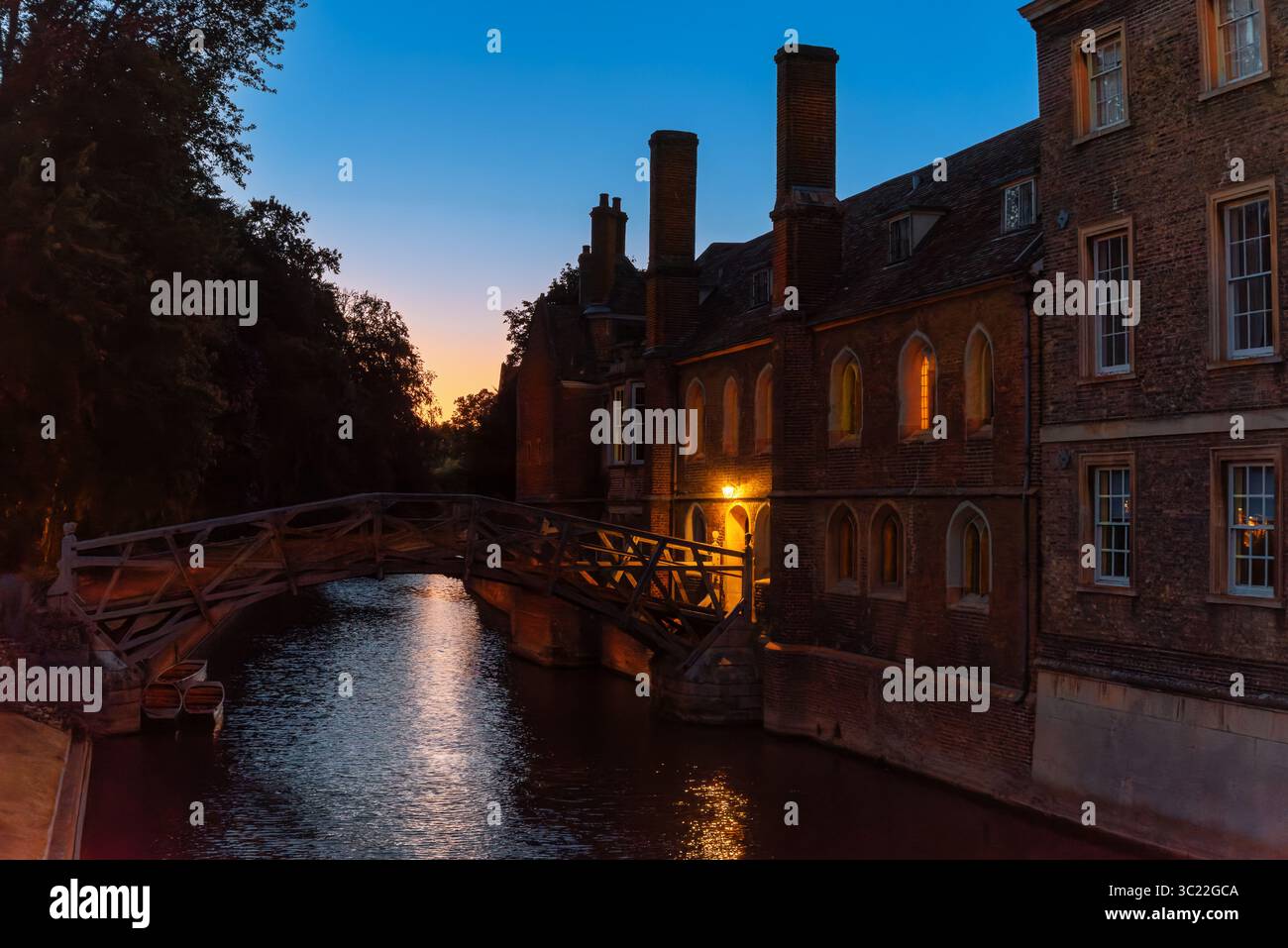 Storico edificio universitario in mattoni e Ponte matematico al tramonto a Cambridge, caratterizzato da stili architettonici gotici e georgiani in Inghilterra Foto Stock