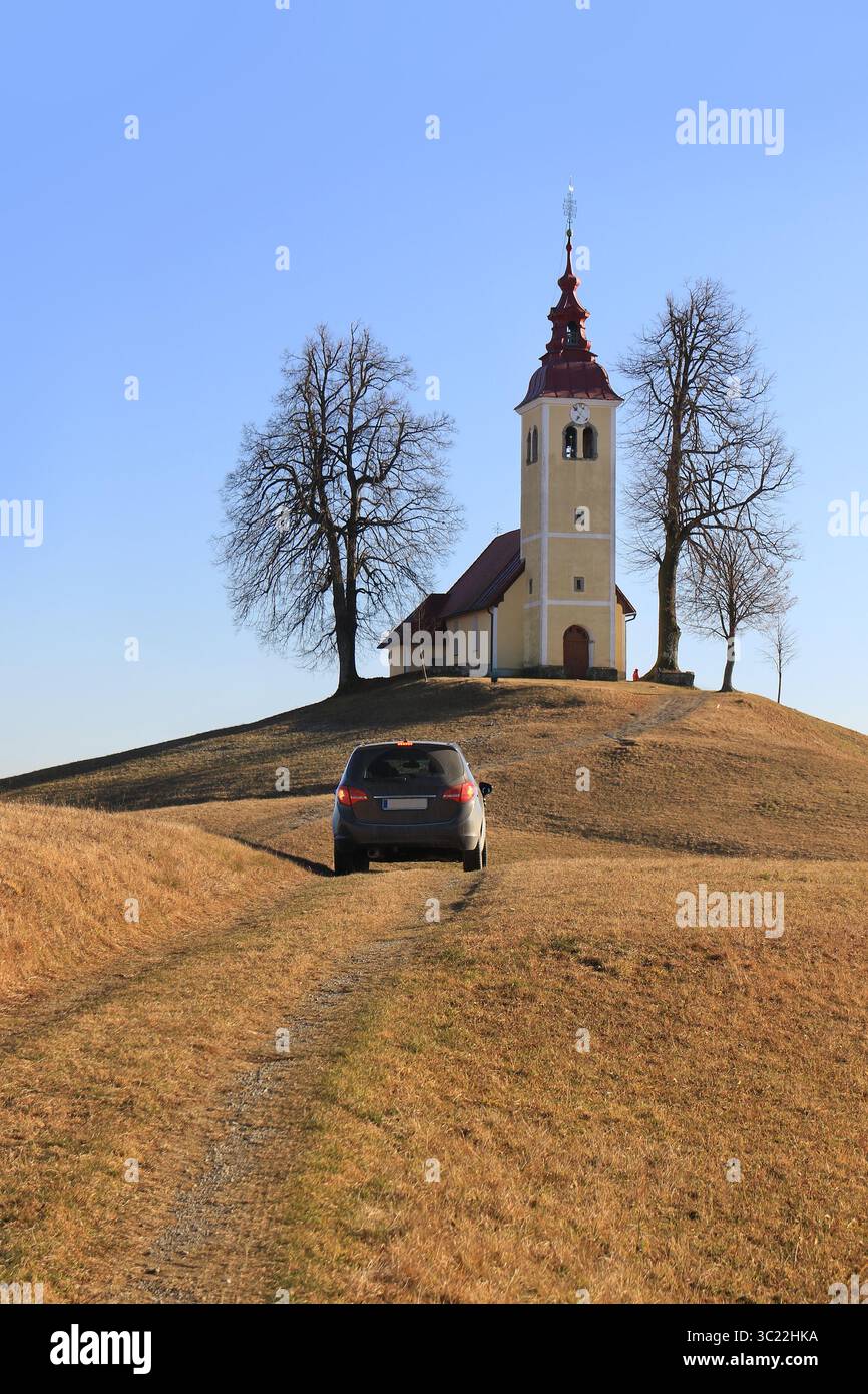 Un'auto che guida verso la chiesa di San Tommaso in Slovenia. Foto Stock