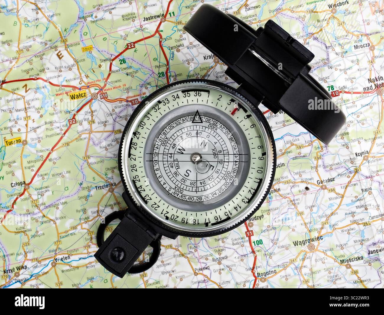 A vintage-style compass placed on a detailed map, symbolizing exploration, navigation, and journey planning. Ideal imagery for themes such as travel, Foto Stock