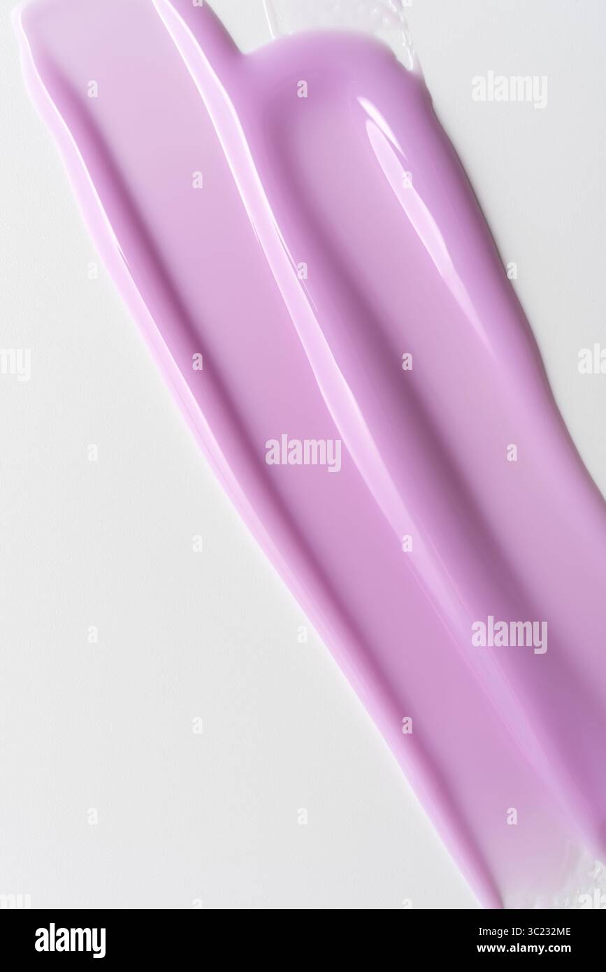 Striscio di gel cosmetico lucido lilla su sfondo bianco. Primo piano astratto di prodotto per unghie o di texture per la cura della pelle con superficie cremosa e lucida per bellezza, crusca Foto Stock