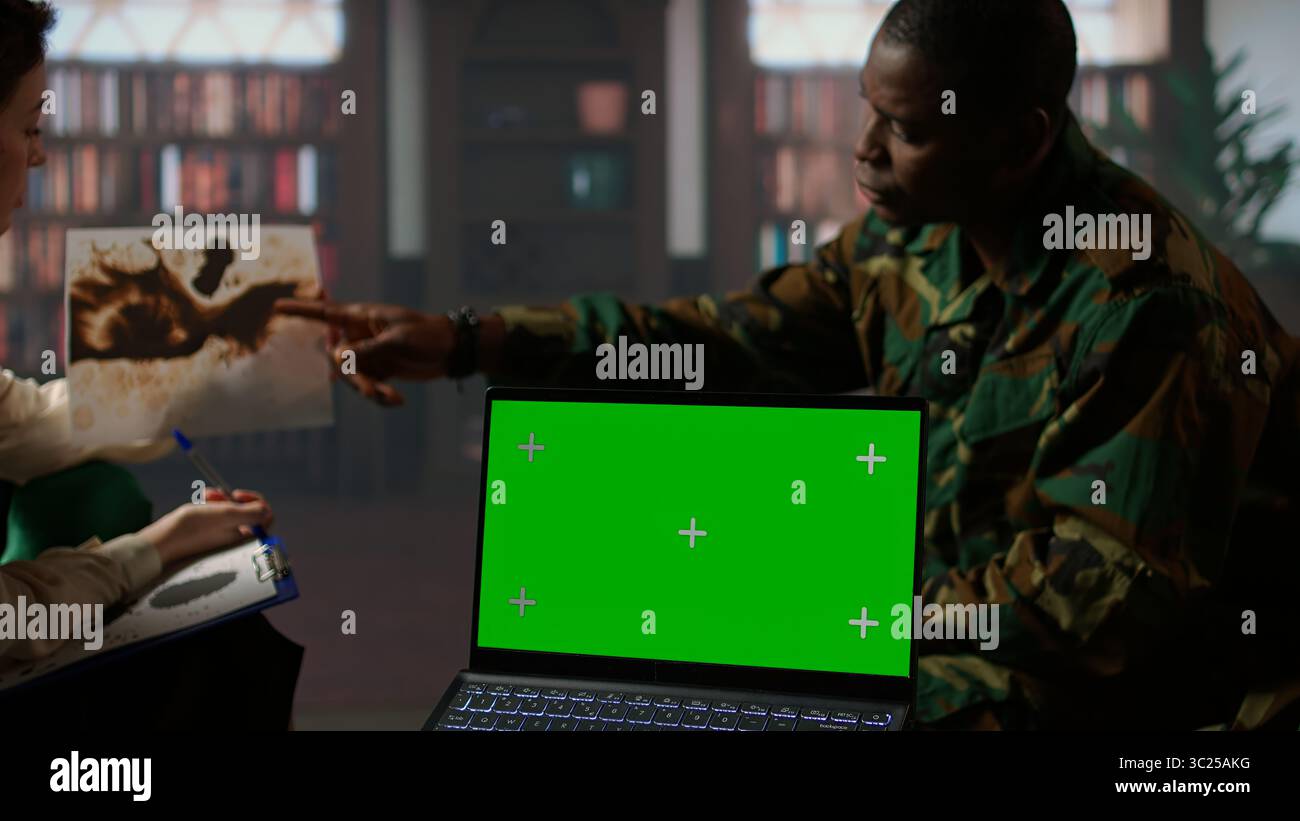 I militari studiano Rorschach Inkblot illustrazione accanto allo schermo verde in terapia con psicologo, affrontando i problemi di PTSD e recupero da trauma. Supporto psicologico. Telecamera A.. Foto Stock